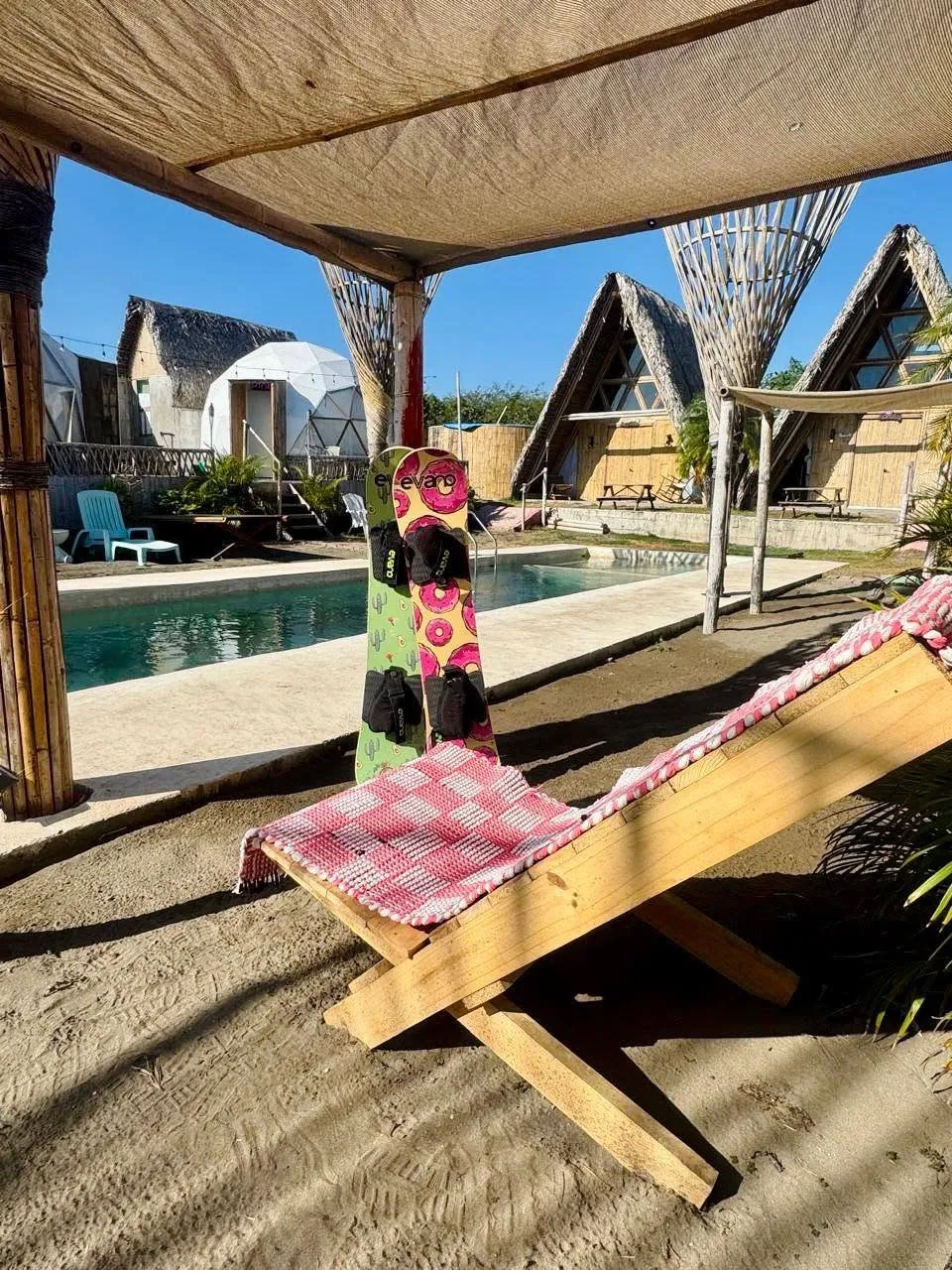 Tabla de sandboard junto a una silla de madera frente a la alberca